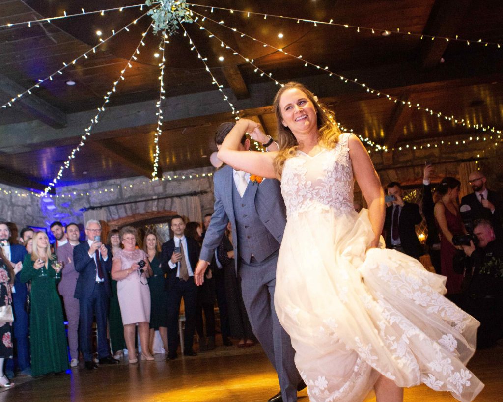 bride and groom dancing, groom is twirling bride around