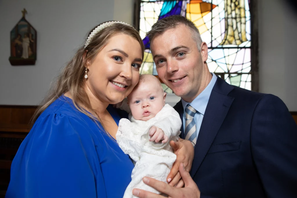 Parents holding their baby during a Galway christening celebration