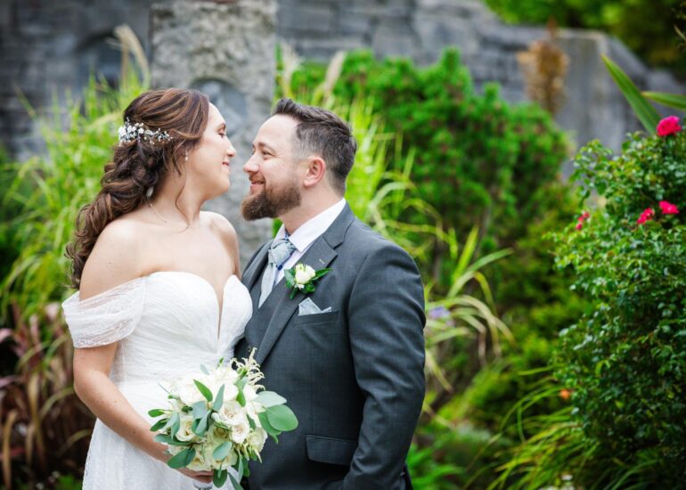 Denise and Gareth smiling together among the garden flowers