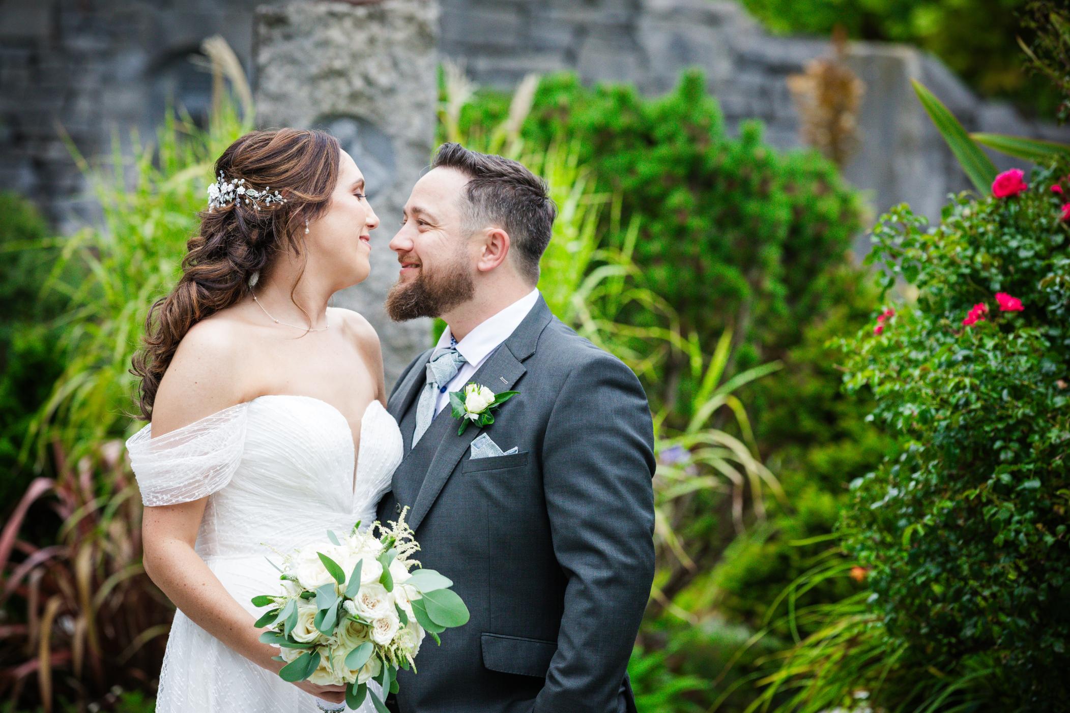 Denise and Gareth smiling together among the garden flowers