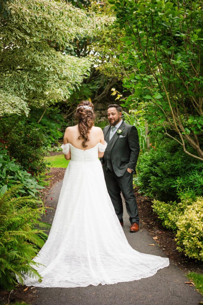 Denise and Gareth standing together on a leafy garden path