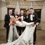 Bride playfully lifted by the groomsmen during a wedding reception in the Galway Bay Hotel