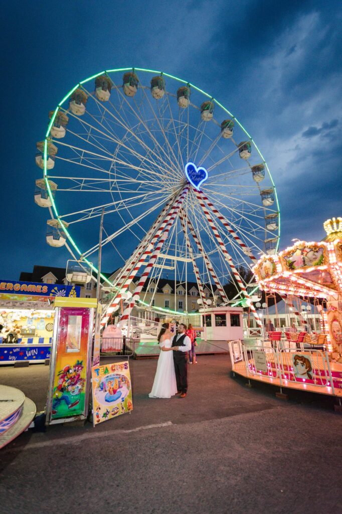 Denise and Gareth beneath the lit Ferris wheel