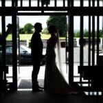 Silhouette of Áine and Rory holding hands in the open doorway of Tynagh Church.