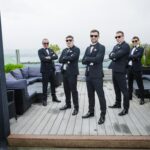 Rory and the lads wearing tuxedos and sunglasses on the rooftop terrace at Loughrea Hotel & Spa.